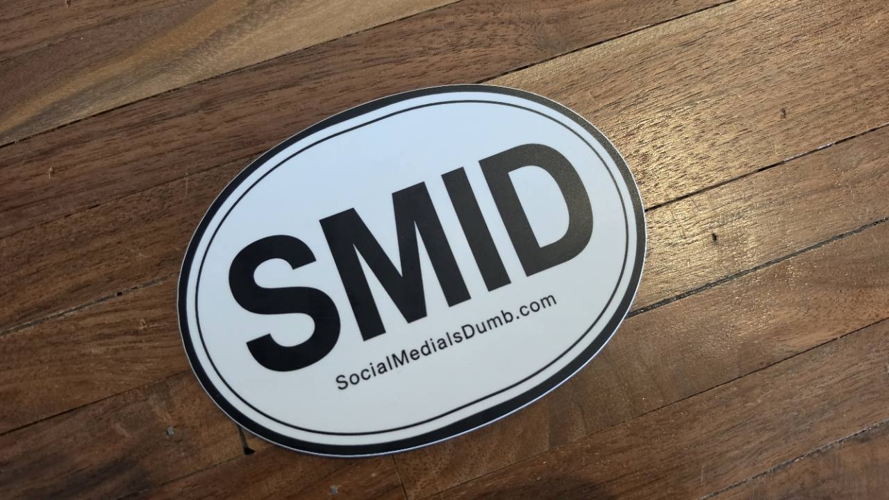 The finished black-and-white SMID oval sticker on a wooden table